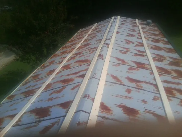 Rusted metal roof panels with new wood purlins before replacement — Storm Damage Roof Repair in Purcell by Roofing Brothers