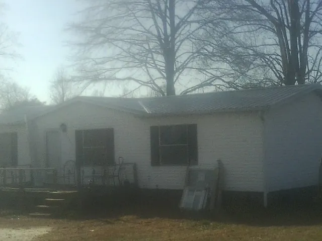 New metal roof on a white painted brick home on a foggy morning in Purcell