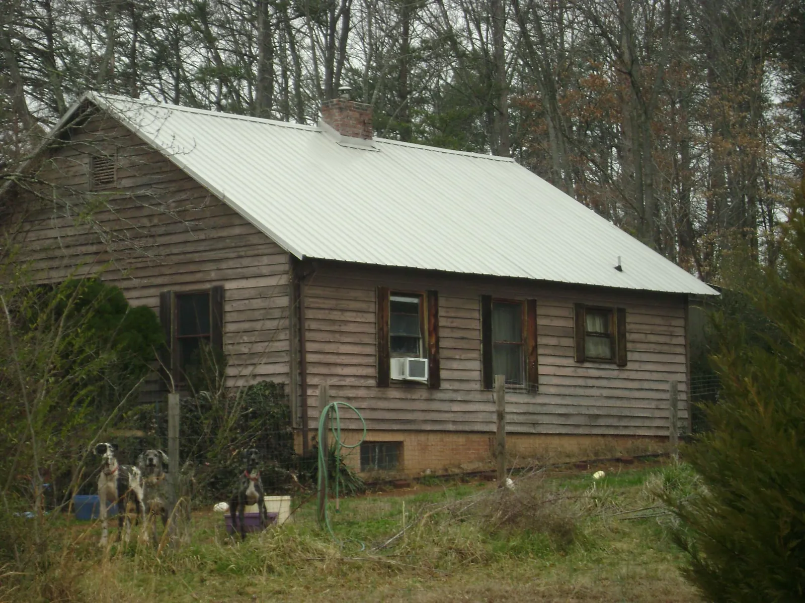 White metal roof on an old wood sided farmhouse, from a Metal Roof Installation job in Purcell